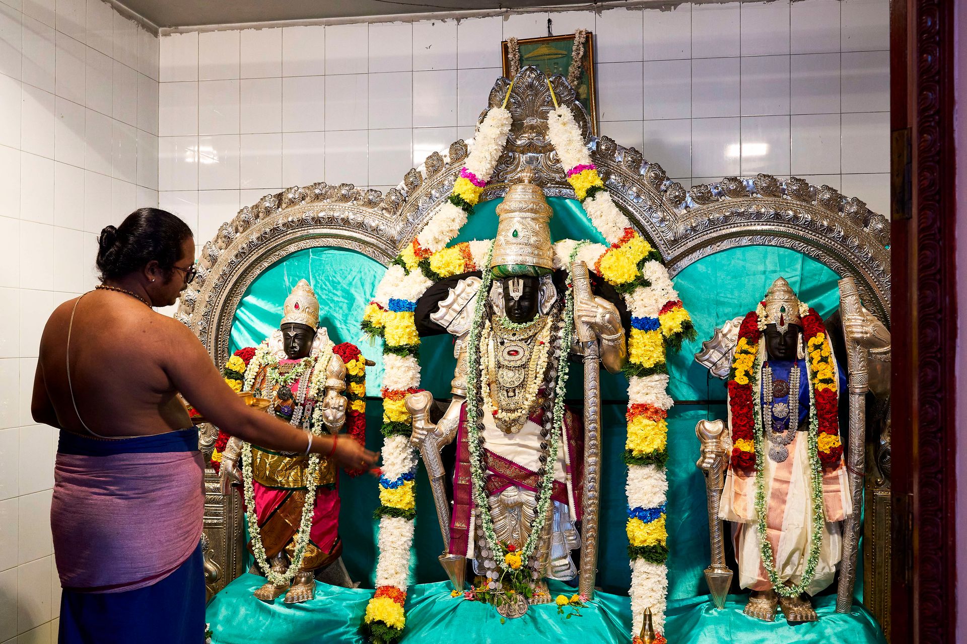 Priest performing a ritual at the Sree Ramar sanctum.